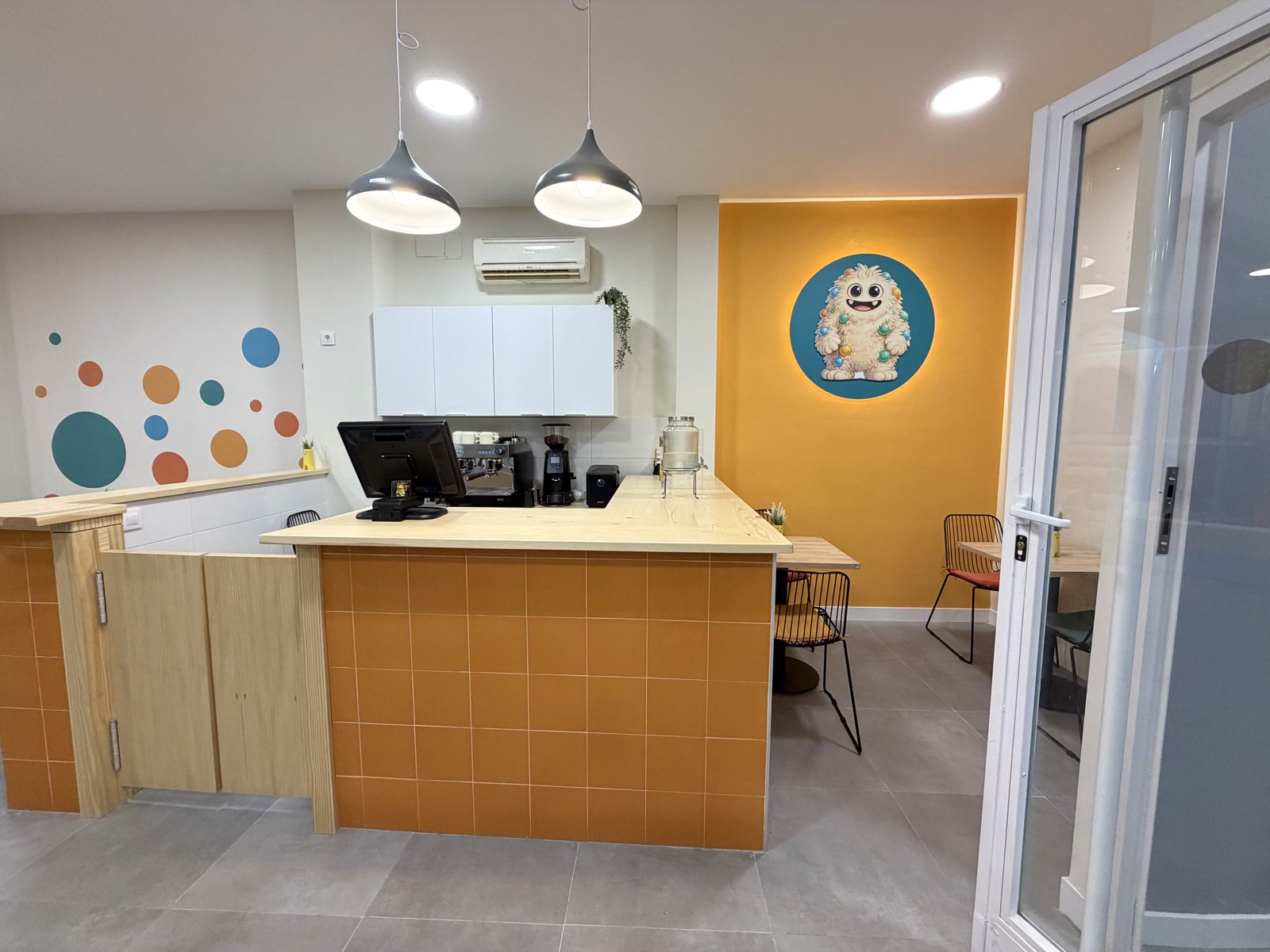 KIDO CAFÉ: barra de cafetería de madera con máquina de café y Kido pintado en la pared
