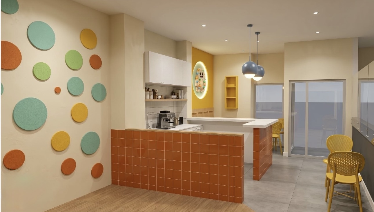 Zona de familias de KIDO PLAY, con cafetería, sillas y pared decorada con círculos de colores de la marca